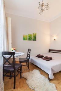 a bedroom with a bed and a table and chairs at Apartments WHITE HOUSE in Lviv