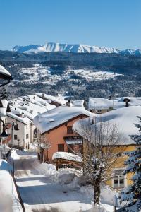 una ciudad cubierta de nieve con montañas en el fondo en Rothaus, en Folgaria