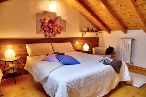 a bedroom with a large white bed with blue pillows at Bed & Breakfast Le Due G in Varese