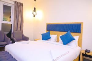 a bedroom with a large white bed with blue pillows at First Inn Hotels Chennai in Chennai