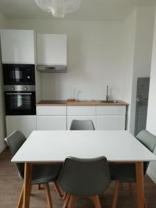 a kitchen with a white table and chairs at Cannes la bocca appartement in Cannes