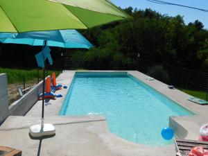 a swimming pool with a green umbrella and a swimming pool at B&B Masseria Majella in Abbateggio