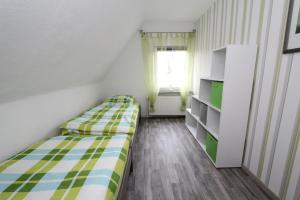 Habitación pequeña con 2 camas y ventana en Ferienhaus Olenbrook en Cuxhaven