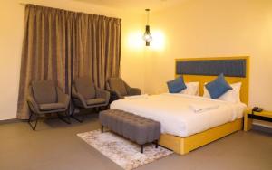 a hotel room with a bed and chairs in it at First Inn Hotels Chennai in Chennai
