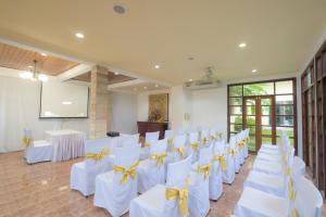 a room with white tables and chairs with yellow bows at Blue Beach Grand Resort And Spa in Rawai Beach