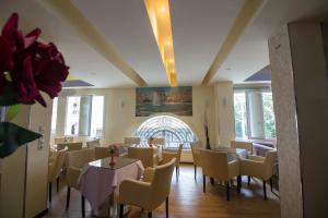 a dining room with tables and chairs and windows at Cosmopolit in Athens