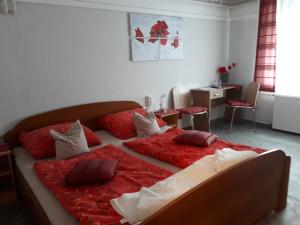 1 dormitorio con 1 cama grande con almohadas rojas en Guest House Tara, en Moravske Toplice