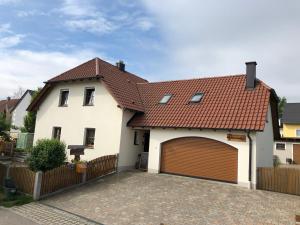 Casa blanca con techo marrón y garaje en Ferienwohnung Diedrichs, en Bodenwöhr