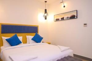 two beds in a hotel room with blue pillows at First Inn Hotels Chennai in Chennai