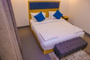 a bedroom with a large bed with blue pillows at First Inn Hotels Chennai in Chennai