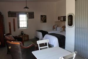 a bedroom with two beds and a table and chairs at Little Artist Cottage in Sutherland