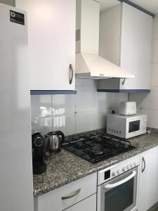 y cocina con fogones y microondas. en PATACONA MARE NOSTRUM APARTMENT II, en Valencia