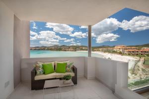 a room with a view of a beach and a couch at Appartamenti Aironi - Your House in Sardinia in Golfo Aranci