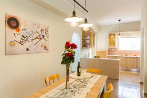 Un comedor con una mesa con un jarrón de flores. en For4 Seasons Home 1 - by Avelink, en Spáta