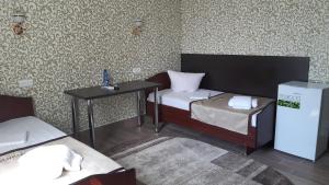 mały pokój z 2 łóżkami i stołem w obiekcie Motel Xameleon w mieście Voznesensk