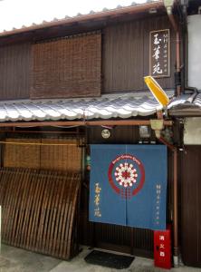 un edificio con un cartel en el costado en Secret Garden Kyoto, en Kioto
