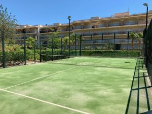 a tennis court in front of a building at Golden Beach Apartamentos in Sant Carles de la Ràpita