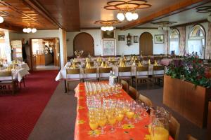 ein Esszimmer mit einem langen Tisch mit Weingläsern in der Unterkunft Hotel Hulfteggpass in Mühlrüti