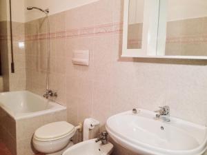a bathroom with a toilet and a sink and a tub at A Due Passi in La Maddalena