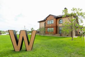 una casa con un cartello a pois sull'erba di WISH Aqua&SPA Resort a Vishenki