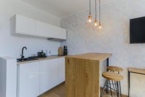 a kitchen with white cabinets and a wooden counter top at Apartament IGO OLD TOWN in Gdańsk