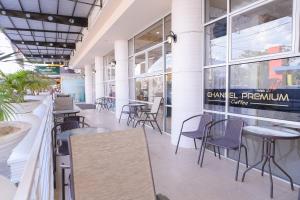 a restaurant with tables and chairs in a building at Capital O 854 Ub Caisar Hotel in Banda Aceh