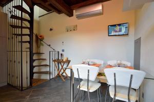 jadalnia ze stołem i białymi krzesłami w obiekcie casa con piscina, giardino e area giochi per bambini w mieście Diano San Pietro