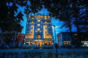 Un grand bâtiment avec des lumières allumées la nuit dans l'établissement LETO Boutique Hotel Zugdidi, à Zugdidi