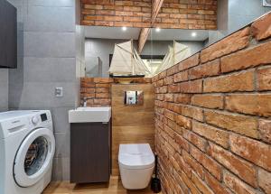 ceglana ściana w łazience z pralką w obiekcie Mieszkanie Dorothy - ACCO RENT w Gdańsku