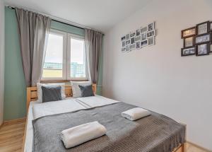 sypialnia z dużym łóżkiem i dużym oknem w obiekcie Mieszkanie Dorothy - ACCO RENT w Gdańsku
