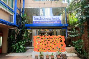 una señal frente a un edificio con plantas en Silom Convent Garden - SHA Extra Plus en Bangkok