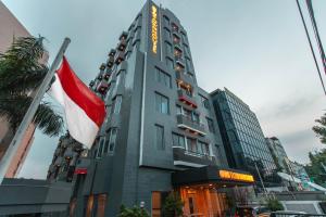 ein Hotelgebäude mit einer Flagge davor in der Unterkunft SUPER OYO Townhouse 1 Hotel Salemba in Jakarta