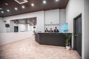 two people at the reception desk of a townhouse at SUPER OYO Townhouse 1 Hotel Salemba in Jakarta