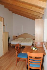 sypialnia z łóżkiem, stołem i krzesłami w obiekcie Agritur alla Veduta w Trydencie