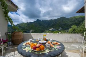 un piatto di frutta su un tavolo sul balcone di Il Mandorlo a Tramonti