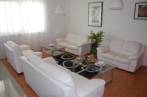 a living room with white couches and a table at Penzion Jarka in Bratislava +18 photos