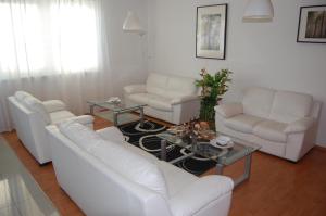 a living room with white couches and a table at Penzion Jarka in Bratislava