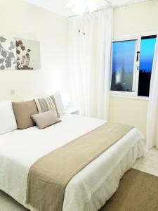 Un dormitorio blanco con una cama grande y una ventana en Regina Gardens, Phase 1 (Sea View) en Pafos