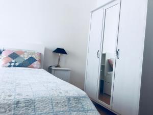 a bedroom with a large white cabinet and a bed at La casa di LULU’ in Deiva Marina