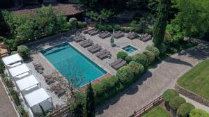 an overhead view of a swimming pool with chaise lounge chairs and trees at Hôtel du Château & Spa - Teritoria in Carcassonne