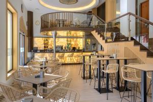 un ristorante con tavoli e sedie e una scala di Hotel Saray a Granada