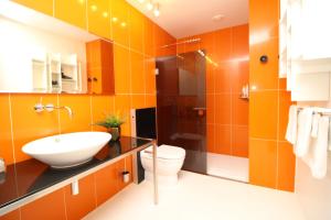 an orange bathroom with a sink and a toilet at Tallinn City Apartments Old Town Square in Tallinn +20 photos
