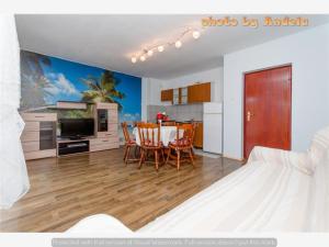 a living room with a table and chairs and a kitchen at Apartmani Anđela in Vinišće