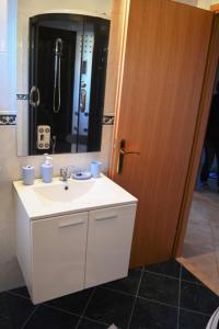 a bathroom with a white sink and a mirror at Apartmani Anđela in Vinišće