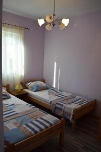 a bedroom with two beds and a chandelier at Apartmani Anđela in Vinišće