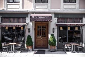 a restaurant with tables and chairs in front of a door at Tiffany Hotel in Geneva