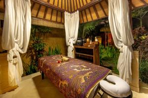 a bedroom with a bed and a table and chairs at Bidadari Private Villas & Retreat in Ubud