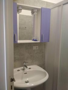 a bathroom with a white sink and a blue cabinet at casa comoda a due passi dal mare in Il Monte