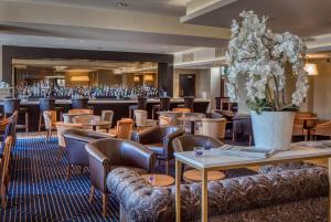 een restaurant met tafels en stoelen en bloemen bij Hotel Colessio in Stirling