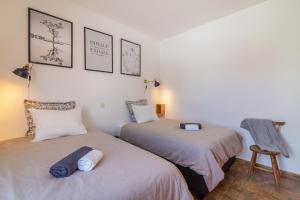 a bedroom with two beds and a chair at H&H seaview in Luz
